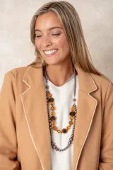 Collar de doble hilera compuesto por cuentas facetadas color ámbar, esferas aterciopeladas marrones y cuentas esféricas metálicas en tonos oscuros.