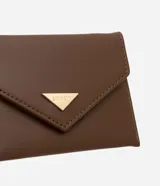 Billetera pequeña color marrón con tapa y cierre de botón a presión. Tiene una placa triangular dorada con el logo de la marca y divisiones para tarjetas.