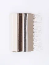 Pie de cama rectangular con flecos blancos en los extremos y diseño a rayas horizontales en tonos beige, marrón y blanco.