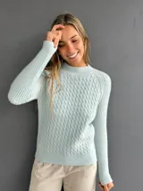 Sweater de punto con textura suave, color celeste, con diseño de ochos en el frente y tejido morley en mangas y espalda. Presenta cuello redondo a la base y mangas largas.