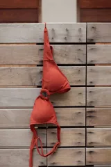 Conjunto de bikini marrón chocolate con tela acanalada. El corpiño es de triángulos fijos unidos por una argolla central y tiene breteles y lazo regulables en la espalda. La bombacha es vedetina con argollas de madera en las caderas.
