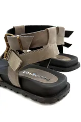 Sandalias de cuero color visón con múltiples tiras y hebillas de ajuste. Suela de goma negra. Diseñadas y hechas en Uruguay.