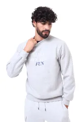 Buzo de cuello redondo en color gris melange, con diseño de estampa frontal con texto en tonos blanco y azul marino. Presenta un corte relajado con puños y ruedo acanalados.