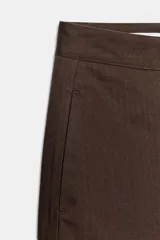 Pantalón de tiro medio con diseño barrel, pernera holgada que se estrecha hacia el tobillo, bolsillos delanteros y bolsillos de plastrón en la espalda. Confeccionado en tejido con textura de espiga, cuenta con cierre frontal de cremallera, botón interior y gancho.