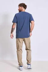 Remera azul marino de algodón con cuello redondo y manga corta. Presenta un pequeño bordado de un pájaro en el área del pecho.