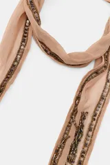 Bandana multiposición de tela ligera color beige, decorada con aplicaciones de abalorios y lentejuelas oscuras a contraste, finalizando en flecos decorativos.