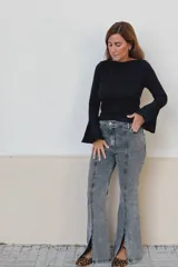 Remera de algodón acanalado color negro, con cuello bote y mangas largas con terminación oxford acampanada.