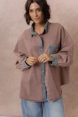 Camisa de denim color verde menta con calce relajado, cuello clásico, cierre frontal con broches metálicos, mangas largas y bolsillo aplicado en el pecho, con detalles en tono gris azulado a contraste en cuello, cartera, bolsillo y puños.
