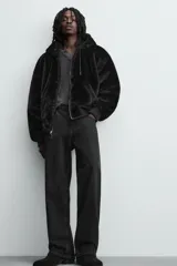 Cazadora bomber reversible de corte relajado confeccionada en tejido técnico. Presenta capucha con interior de pelo sintético, cierre frontal con cremallera de doble dirección, bolsillos laterales y puños y bajo con acabado en rib elástico.