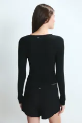 Remera de manga larga ajustada al cuerpo, con cuello redondo y diseño acanalado.