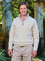Sweater de lana Lambswool color verde oscuro, de manga larga, con cuello alto tipo polo y medio cierre frontal metálico con tirador personalizado de la marca Tranquera. Presenta un pequeño bordado rojo en el pecho.
