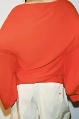 Jersey de punto con cuello barco y mangas anchas tipo murciélago, de diseño holgado y fluido.