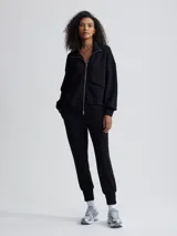 Campera negra de corte holgado con cierre bidireccional, cuello alto y bolsillos frontales.