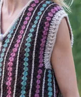 Chaleco tejido a mano en crochet de lana merino, con diseño de rayas verticales en marrón, fucsia y verde, escote en V y cierre frontal con botones forrados.