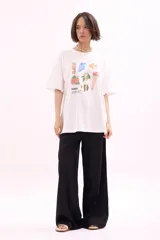 Remera blanca de manga corta, corte oversize, con estampa colorida de motivos marinos y botánicos en el frente.