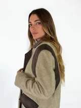 Tapado de paño de lana en color beige con detalles en pana marrón oscuro en hombros, cuello y bolsillos. Diseño de corte recto y estructura clásica.