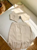 Minifalda color beige de cuero sintético con flecos en el ruedo.