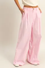 Pantalón de vestir color rosa claro, tiro alto, con pliegues frontales y pierna muy ancha.