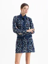 Minifalda de denim con diseño de guipiure floral, bolsillos cargo laterales y cinturón incorporado con hebilla metálica.