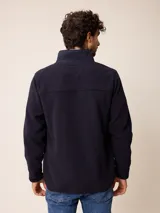 Campera de polar color verde militar, con cierre frontal completo, cuello alto y bolsillo en el pecho con cierre y detalle en tela técnica.