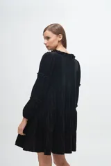 Vestido corto de terciopelo color cobre, con diseño de volados en capas, cuello redondo con detalle de volado y mangas largas con fruncidos.