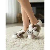 Pantuflas de peluche con diseño de vaca, confeccionadas en piel sintética suave. Cuentan con suela de goma antideslizante y diseño abierto en el talón.