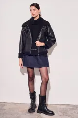Campera negra de cuero sintético con cuello y puños de piel sintética. Corte oversize y cierre frontal con cremallera.
