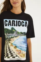 Remera negra de algodón con cuello redondo, mangas cortas y estampa frontal de paisaje playero con la inscripción "Carioca".