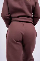 Pantalón jogger color marrón con cintura elástica, cordón ajustable y logo bordado en blanco.