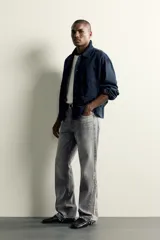 Jeans flare fit de denim de algodón en color celeste con lavado efecto desgastado. Presentan diseño de cinco bolsillos, tiro medio, cierre frontal con cremallera y botón, y bajo con acabado irregular.