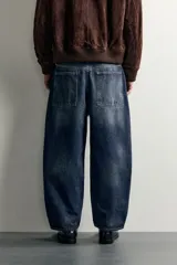Jeans tapered wide fit de hombre, confeccionados en denim de algodón con efecto lavado en tono azul oscuro. Presentan diseño de cinco bolsillos, tiro medio, corte relajado y cierre frontal con cremallera y botón.