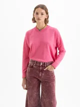Sweater rosa de largo hasta la cadera, con mangas largas y tejido en mezcla de lana merino y algodón. De silueta holgada y cuello redondo.