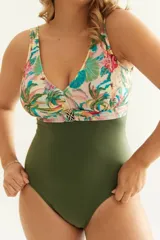 Malla entera combinada, con corpiño estampado con motivos tropicales y parte inferior verde militar. Presenta escote en V, breteles anchos y aplique metálico en el centro.