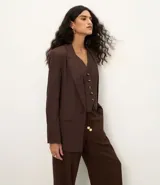 Blazer celeste de viscosa y lino, con cuello inglés, cierre de un botón y solapas.