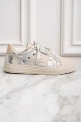 Zapatillas bajas de cuero color crema con detalles plateados y estrella lateral.