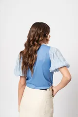 Blusa azul de cuello redondo y manga corta abullonada con puño elástico.