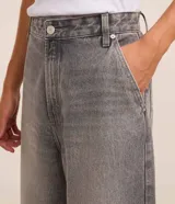 Pantalon baggy de jean gris con efecto deslavado, tiro medio, cierre con boton y cremallera, trabillas para cinturon y bolsillos delanteros y traseros.