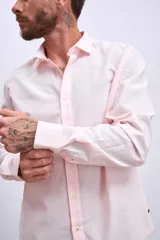 Camisa de manga larga color rosa claro con botones. Corte clásico.