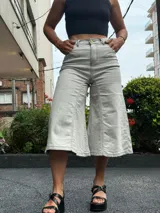 Jean capri de tiro alto en color gris claro, confeccionado con lycra para mayor comodidad. Presenta perneras amplias y corte midi, simulando una falda pantalón.