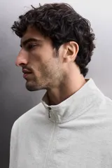 Sudadera de corte relajado con cierre frontal de cremallera, confeccionada en tejido ligero de mezcla de algodón. Presenta cuello subido, manga larga, bolsillos laterales ocultos en costura y acabados en rib.