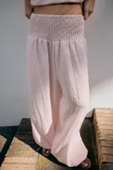Pantalón baggy de tiro medio color rosado, con cintura elástica fruncida tipo nido de abeja y bajos ajustables con cordones.
