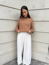 Sweater color crema tejido con diseño en ochos y cuello redondo.