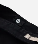 Pantalón skinny de sarga color negro, de talle alto con trabillas para cinturón, cierre de cremallera y botón, y bolsillos funcionales.
