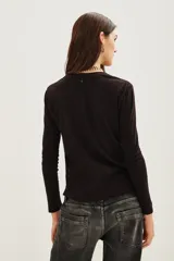 Remera de manga larga color negro, confeccionada en algodón, con estampa frontal bordada en hilo metalizado con la frase 'PARIS JE T'AIME'.