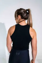 Musculosa negra de algodón elastizado, con cuello redondo y corte ajustado al cuerpo. Presenta un estampado pequeño en el centro del pecho.