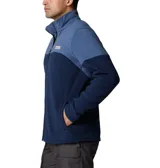 Polar Columbia de hombre, modelo Basin Trail III Full Zip, color azul marino con bloques de color azul más claro en hombros y parte superior del pecho. Presenta cuello alto, cierre frontal completo y bolsillos laterales con cierre.