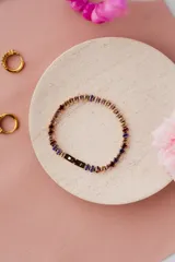 Pulsera de acero quirúrgico con baño de oro, adornada con circonitas de corte ovalado en tonos multicolor.