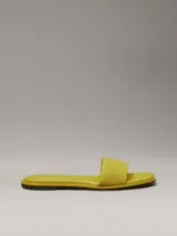 Ojotas amarillas de lona con logo de Calvin Klein grabado en la tira.