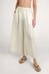 Pantalón fluido color crema, de corte ancho y relajado, con cintura elástica fruncida.