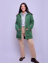 Camisa leñadora de paño en color verde, con cuello clásico, cierre frontal de botones y bolsillos delanteros amplios.